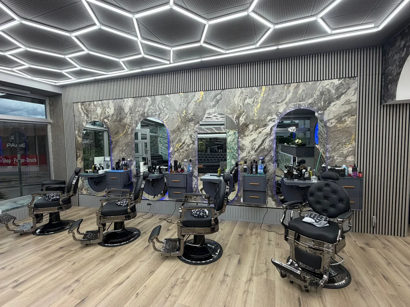 Innenbereich des Salons Bruck Friseur mit Marmor-Optik und Bedienplätzen